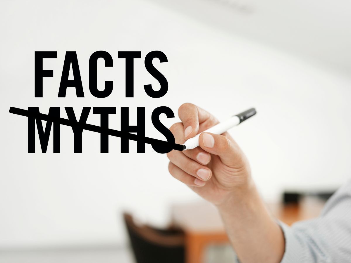 Person crossing out the word 'MYTHS' and writing 'FACTS' on a whiteboard, representing the clarification of Common Myths About Personal Injury Law.