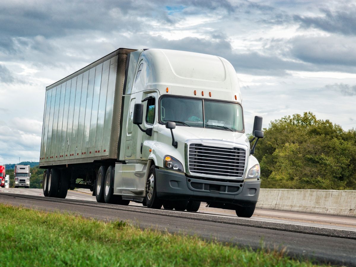 White tractor-trailer truck on the highway, depicting potential cases for a San Antonio Tractor-Trailer Accident Lawyer. Contact us for expert legal assistance.